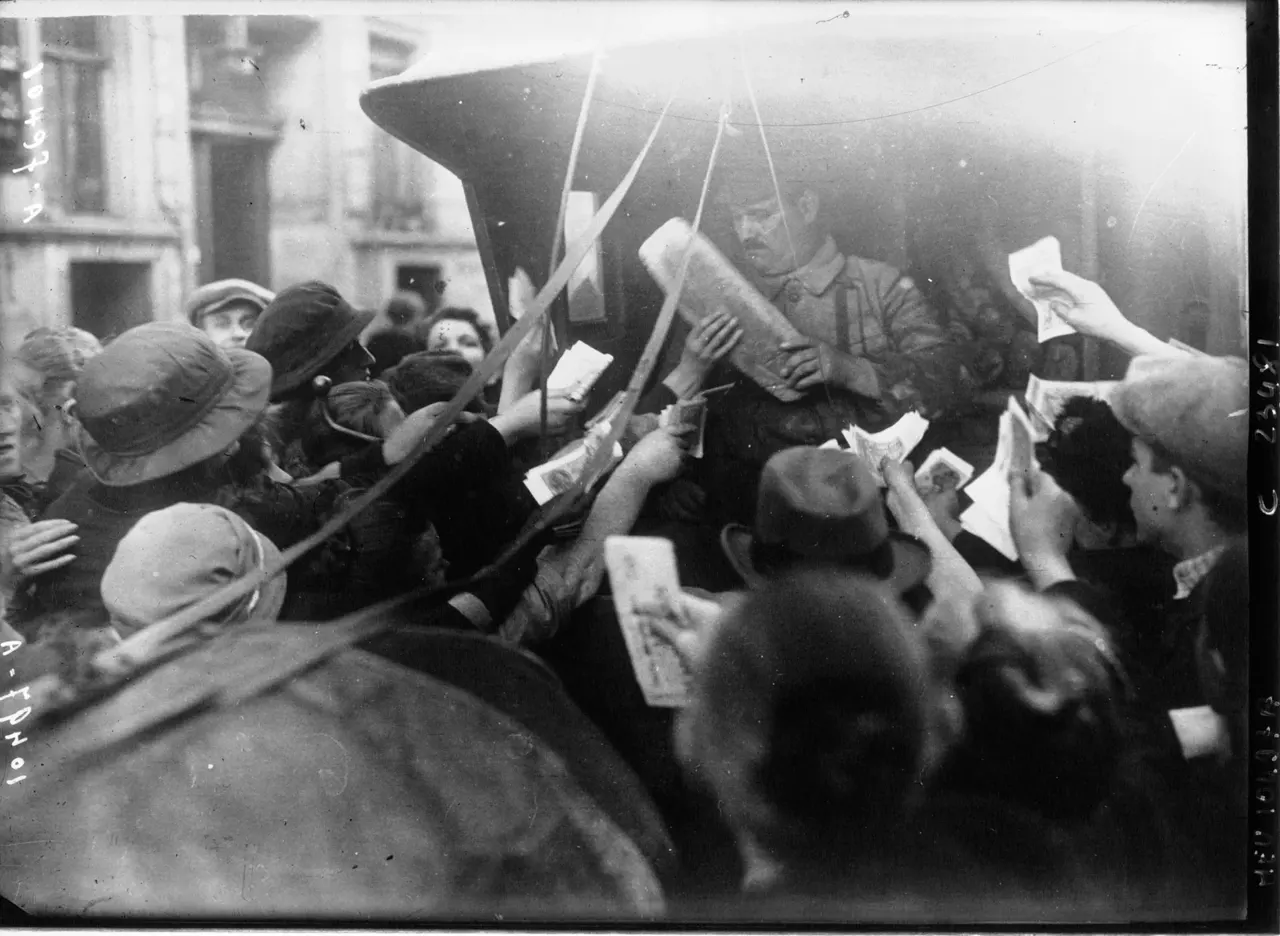 1923 Berlin'de kalabalık bir grup insan, bir fırıncının arabasının etrafını sarmış; eller havada banknotlar tutuyor, arabadaki adam kucağında büyük bir ekmek taşıyor.
