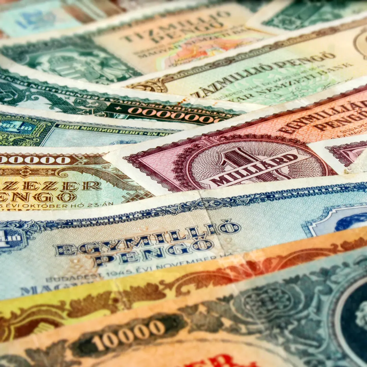 Yelpaze gibi dizilmiş Macar pengő banknotları; üzerlerinde on bin, yüz bin, bir milyon, on milyon, yüz milyon ve bir milyar pengő yazıyor.